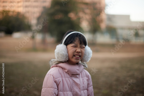 寒い日に公園で遊んでいる小学生の女の子の顔写真