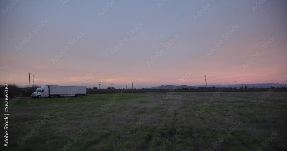 A pastel sky over the Sierra Nevada mountains with power lines and a 18 wheel truck in the foreground in Clovis, CA, USA A pastel sky over the Sierra Nevada mountains with power lines and a 18 wheel truck in the foreground in Clovis, CA, USA