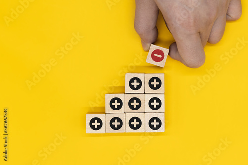 Fotografija Plus and minus icons on wooden cubes