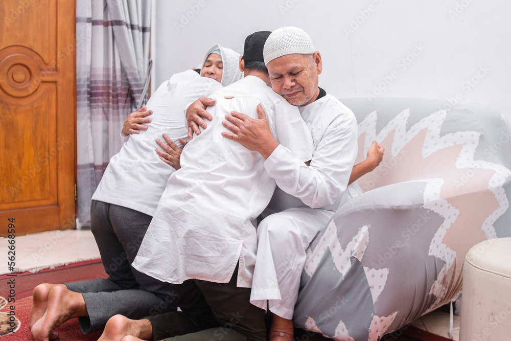 Two son hugging his parents to apologize when celebrating  Eid Mubarak ramadan. 