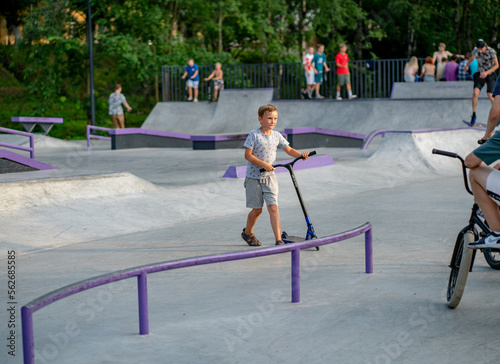 boy exercising on a scooter in a skatepark
