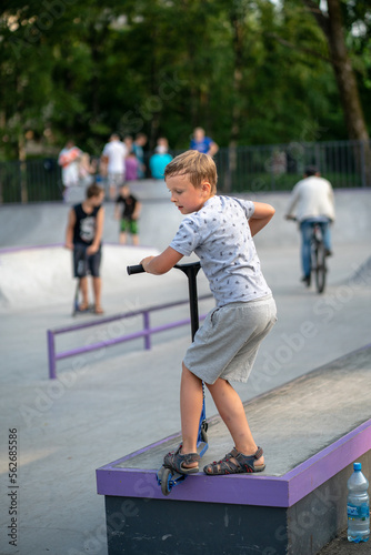 boy exercising on a scooter in a skatepark