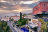 Taormina, Sicily, Italy. Cityscape image of picturesque town of Taormina, Sicily with volcano Etna in the background at sunset.