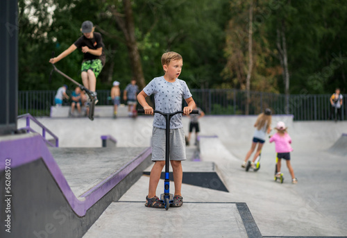 boy exercising on a scooter in a skatepark