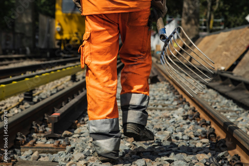 Gleisarbeiter mit Forke auf Schienen