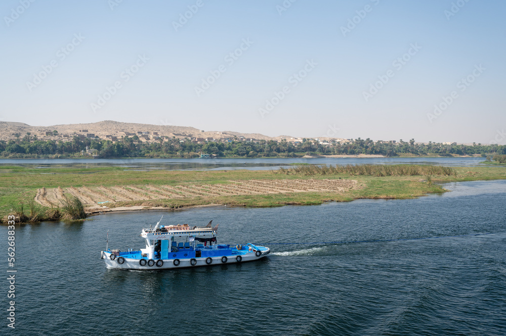 Blue and white ship sailing at the Nile river, Egypt