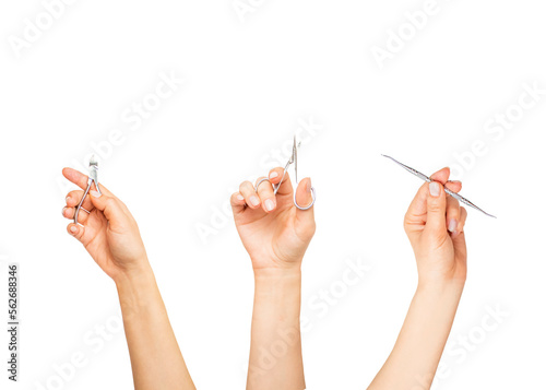 hands hold tools for manicure and pedicure, on a white background, scissors for manicure,nail nippers and a curette, 