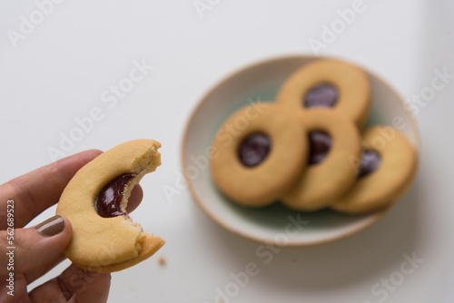 Half bitten marmalade butter cookie in hand 