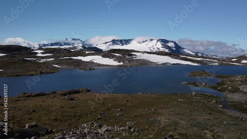 Zoom out scenery with snow peak mountains and a lake