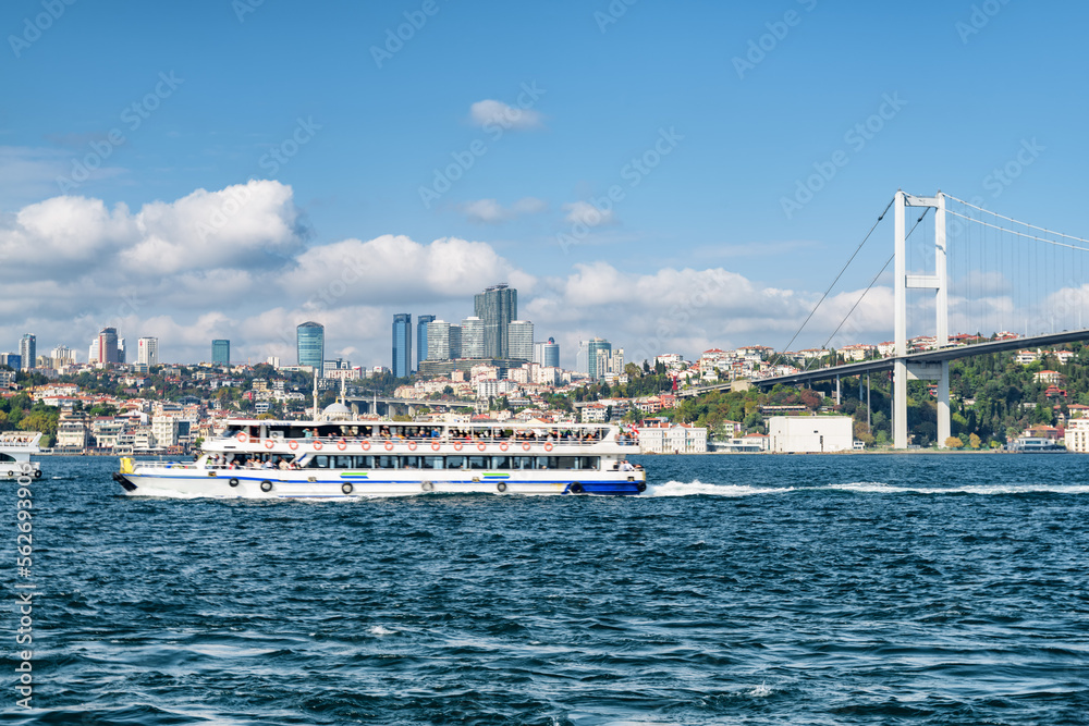 Tourist boat crossing the Bosporus. View of the Bosphorus Bridge