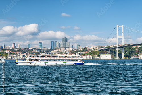 Tourist boat crossing the Bosporus. View of the Bosphorus Bridge