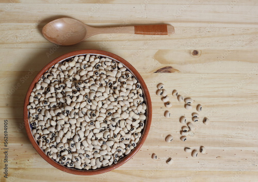 Uncooked Black Eyed Peas in Bowl on Wooden Table Uncooked Black Eyed Peas in Bowl on Wooden Table