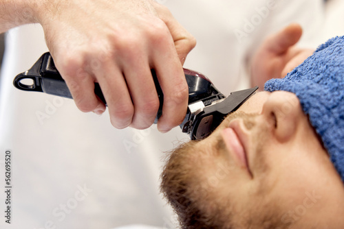 male hands of barber with hair clipper