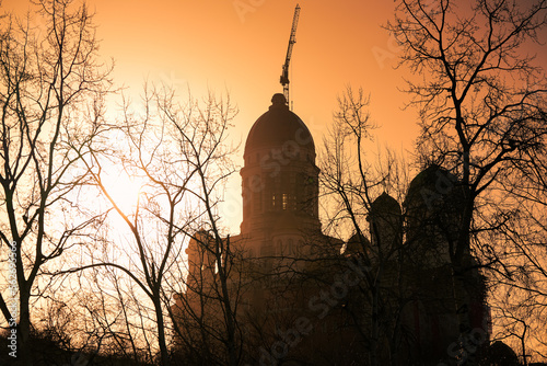 Silhouette of People's Salvation Cathedral (Catedrala Mantuirii Neamului in Romanian language) under construction during a winter sunrise in Bucharest. photo