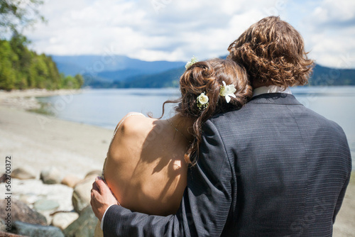 A young couple embrace each other while at the looking out at Burrard Intlet, Vancouver B.C. photo