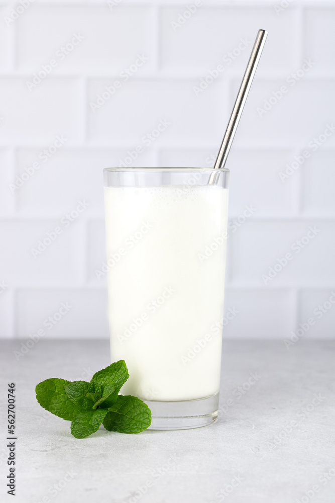 A popular Indian cold drink is Lassi. Yoghurt drink with spices and mint on a white background. Copy Space. A popular Indian cold drink is Lassi. Yoghurt drink with spices and mint on a white background. Copy Space.