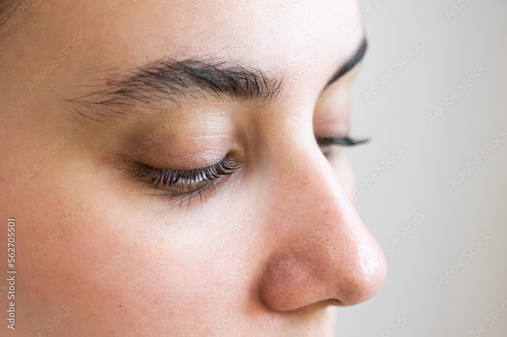 Close-up of a caucasian woman after eyelash lamination procedure. 