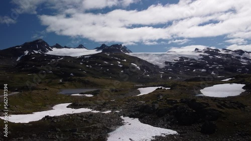 Glaciers in the mountains of norway with a lake in the foreground