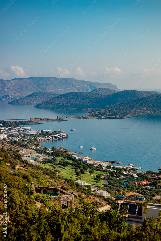Stunning view from a hill of famous Elounda town, mountains and blue sea