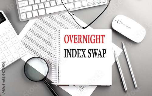 Overnight Index Swap text on notepad on chart with keyboard and calculator on grey background photo