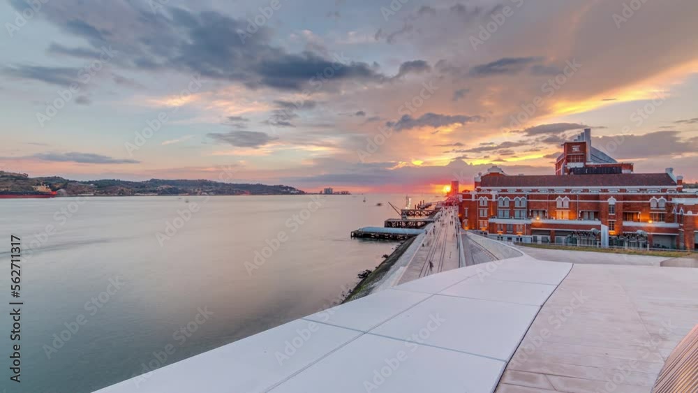 Sunset panorama with the Padrao dos Descobrimentos (Monument to the Discoveries) timelapse. Famous monument on the banks of the River Tagus in Lisbon with dark clouds and rain on background.