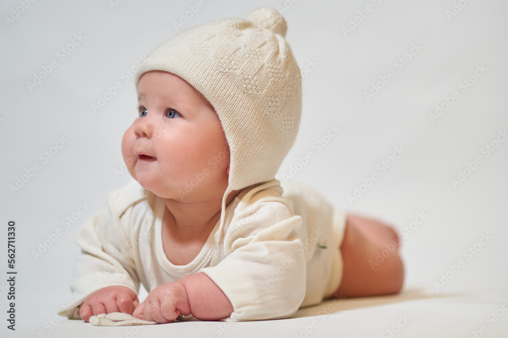 Portrait of an infant wearing light clothes and a knitted hat Portrait of an infant wearing light clothes and a knitted hat