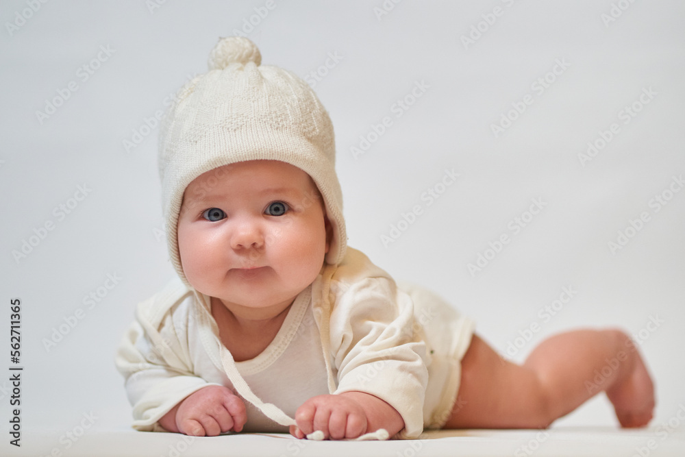 Portrait of an infant wearing light clothes and a knitted hat Portrait of an infant wearing light clothes and a knitted hat