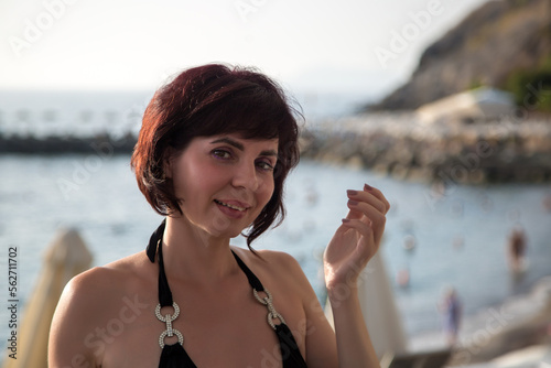 Close-up portrait of brunette woman with short haircut near the sea.