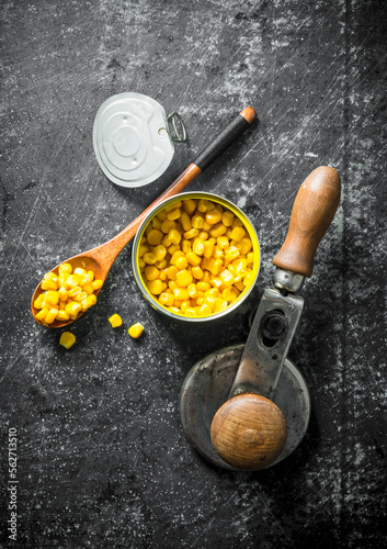 Canned corn in a tin can and a spoon.