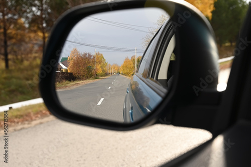view through the side mirror of the autumn forest