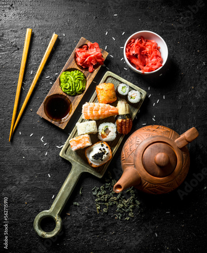 Sushi rolls with shrimp, salmon and vegetables on a cutting Board with chopsticks.