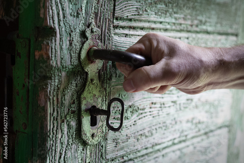a man stands in front of an old door and a key with a lock hand