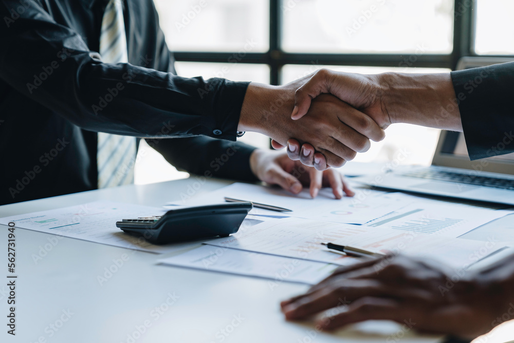 Two young Asian businessmen join hands and agree to invest in a business venture. Two young Asian businessmen join hands and agree to invest in a business venture.