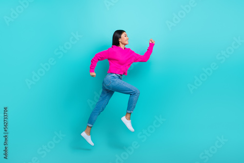 Full length photo of sweet adorable lady wear pink sweater running fast jumping high isolated turquoise color background