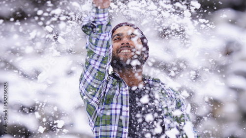 Indian boy enjoying and playing with snow during winter snowfall