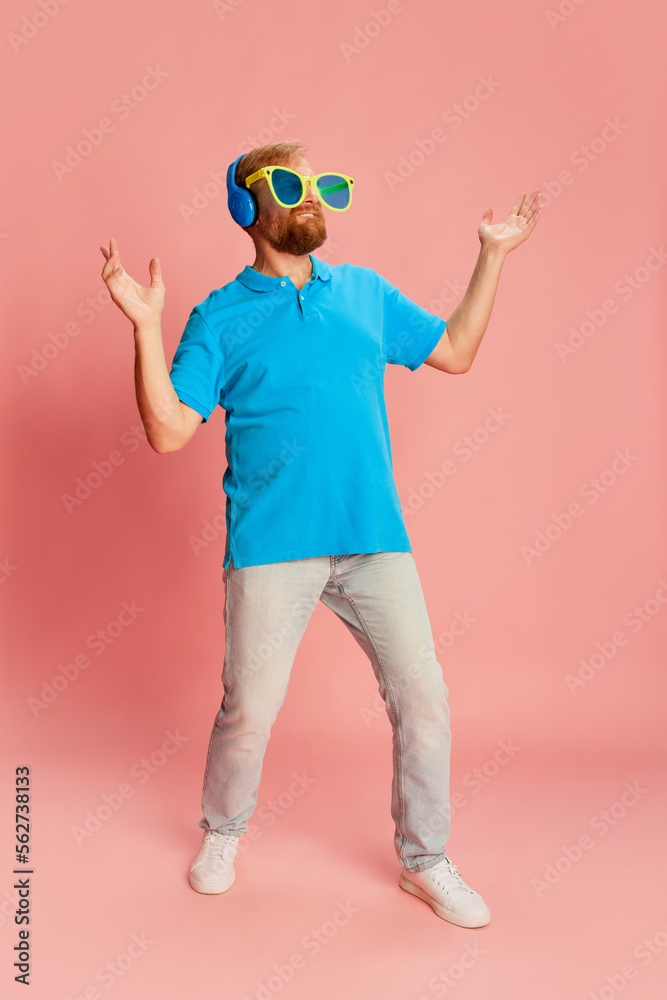 Happy man in casual style clothes and funny huge eyewear with funky facial expression over pink background. Concept of funny meme emotions, happiness, ad, sales. Happy man in casual style clothes and funny huge eyewear with funky facial expression over pink background. Concept of funny meme emotions, happiness, ad, sales.