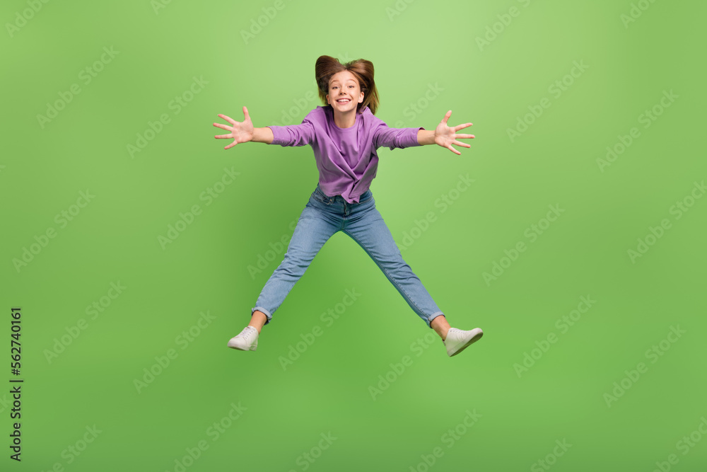 Full size photo of optimistic good mood girl dressed jeans purple pullover jumping cuddling you isolated on green color background Full size photo of optimistic good mood girl dressed jeans purple pullover jumping cuddling you isolated on green color background