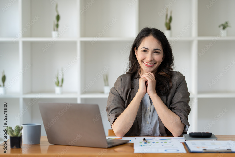 Young Asian businesswoman sitting with her hands on the desk with a happy smile at successful work The results were as planned. management concept management. Young Asian businesswoman sitting with her hands on the desk with a happy smile at successful work The results were as planned. management concept management.