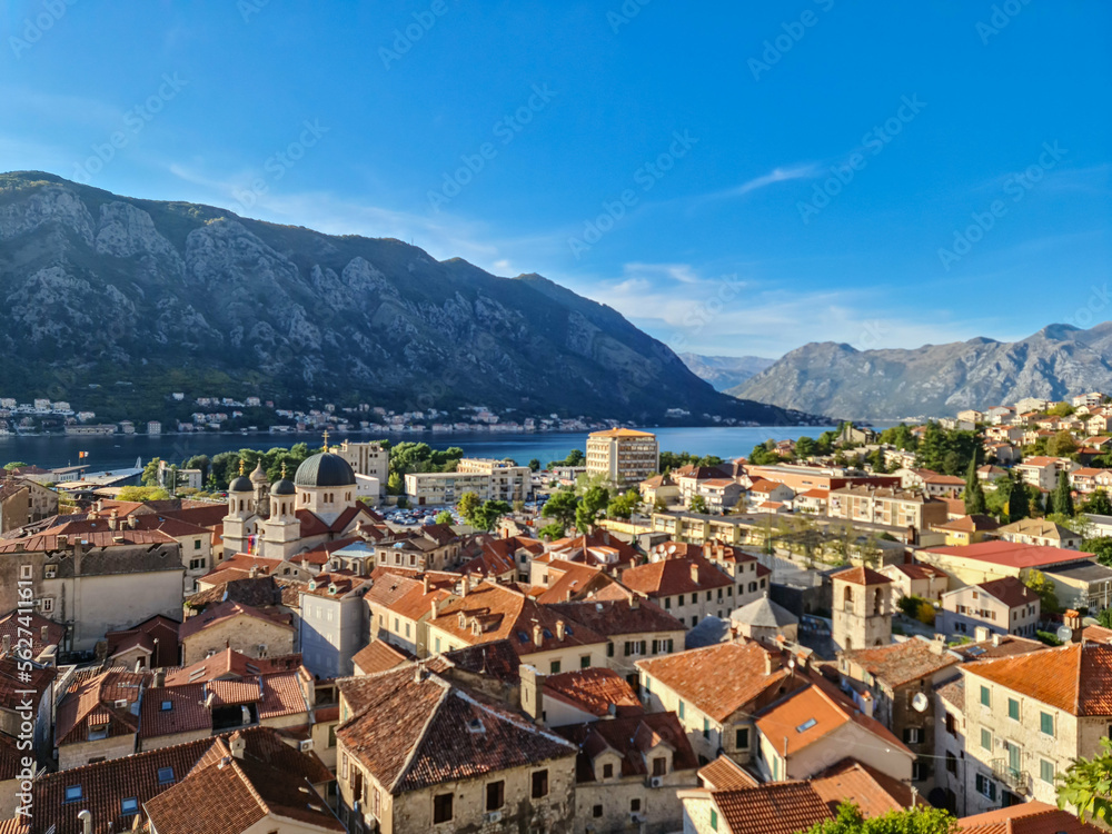Aerial view of Kotor bay, town and harbour in sunny summer at Adriatic Mediterranean Sea, Montenegro, Balkan, Europe. Fjord winding along coastal towns. Lovcen park. Seen from Kotor fortress wall