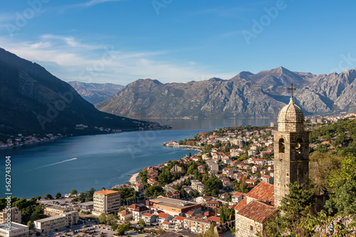 Panoramic view from Kotor city walls on Church of Our Lady of Remedy and Kotor bay in sunny summer, Adriatic Mediterranean Sea, Montenegro, Balkan Peninsula, Europe. Fjord winding along coastal towns © Chris