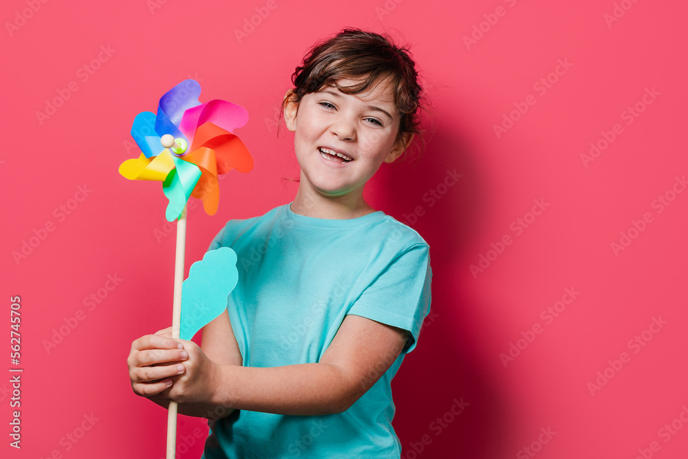 Cute girl holding pinwheel and looking at camera Cute girl holding pinwheel and looking at camera