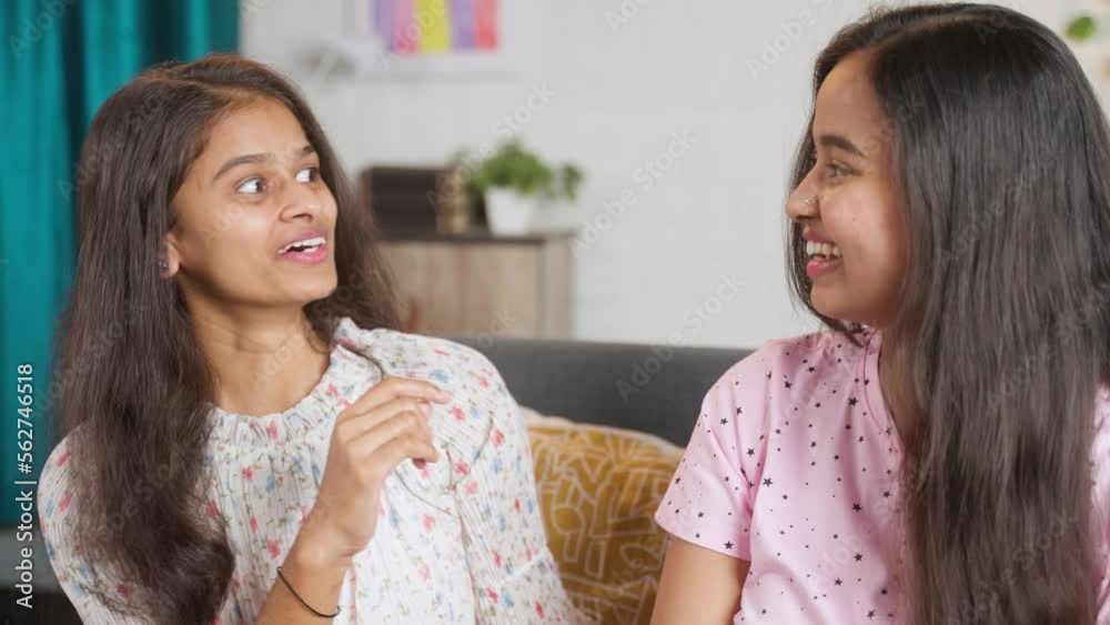 young teenager girl sharing secrets to sisterat home - concept of whispering, communication and trust. young teenager girl sharing secrets to sisterat home - concept of whispering, communication and trust.