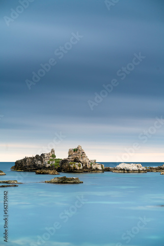 View of rocks on sea after sunset time with beautiful blue sea water and cloudy sky, long exposure photography on outdoor
