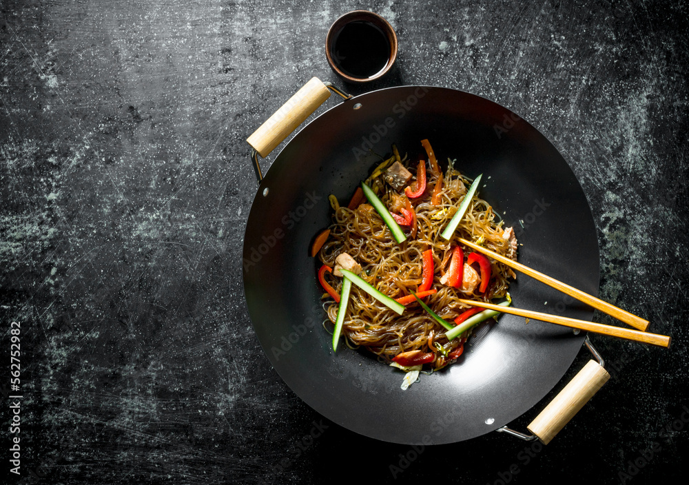 Chinese wok. Asian cellophane noodles with vegetables and chicken in a  frying pan wok. Photos | Adobe Stock