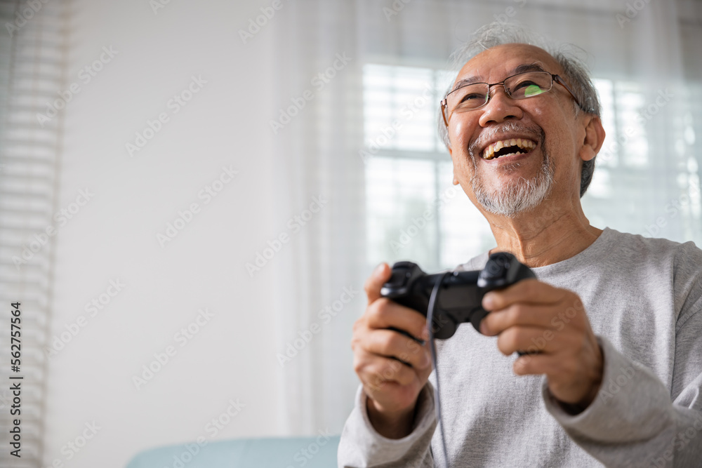 Funny retirement elderly smile sitting on sofa life gaming, lifestyle senior old man enjoying holding joystick playing video game at home, gamer mature man hands using game controller play videogame Funny retirement elderly smile sitting on sofa life gaming, lifestyle senior old man enjoying holding joystick playing video game at home, gamer mature man hands using game controller play videogame