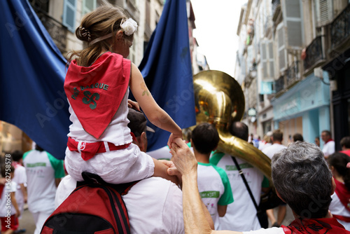 Petite fille sur les épaules de ses parents au défilé des bandas des Fêtes de Bayonne photo