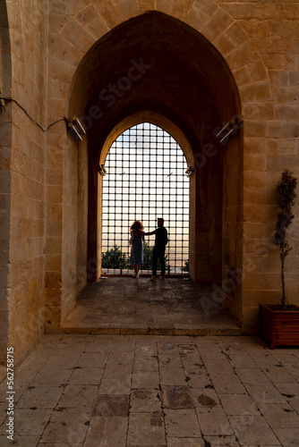 Inside viev of Kasimiye Madrasah of Mardin Province, beautiful stone architecture religion school with colorful sunset light and fences and people © Aytug Bayer