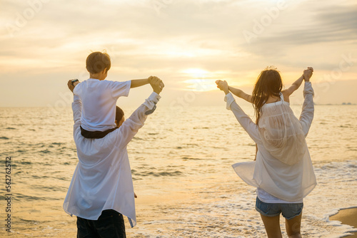 Happy family day. Parents carrying children on shoulders at the beach on sunset time, Father, Mother and kids playing together outdoors on summer beach, Family on holiday summer vacation travel