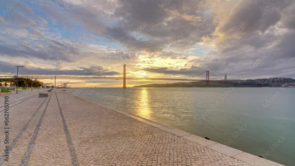 Lisbon city sunrise with April 25 bridge panoramic timelapse, River and waterfront early morning. Colorful cloudy sky