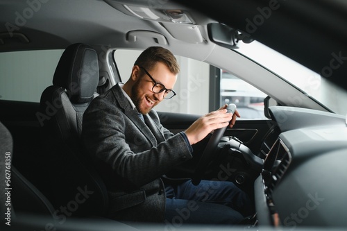 Man adult customer male buyer client wears classic suit white shirt chooses auto wants to buy new automobile touch check car in showroom vehicle salon dealership store motor show indoor. Sales concept © Serhii